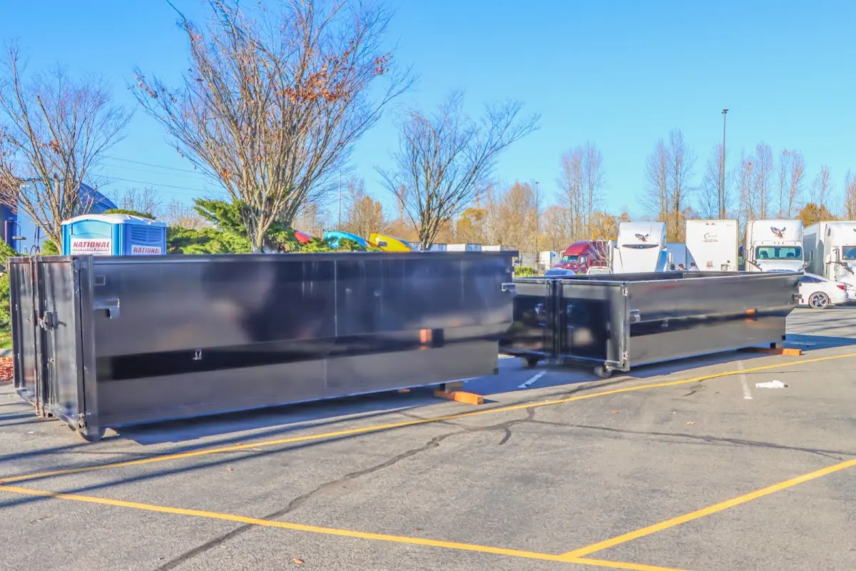 Professional dumpster rental service with roll-off container on residential driveway in Byram